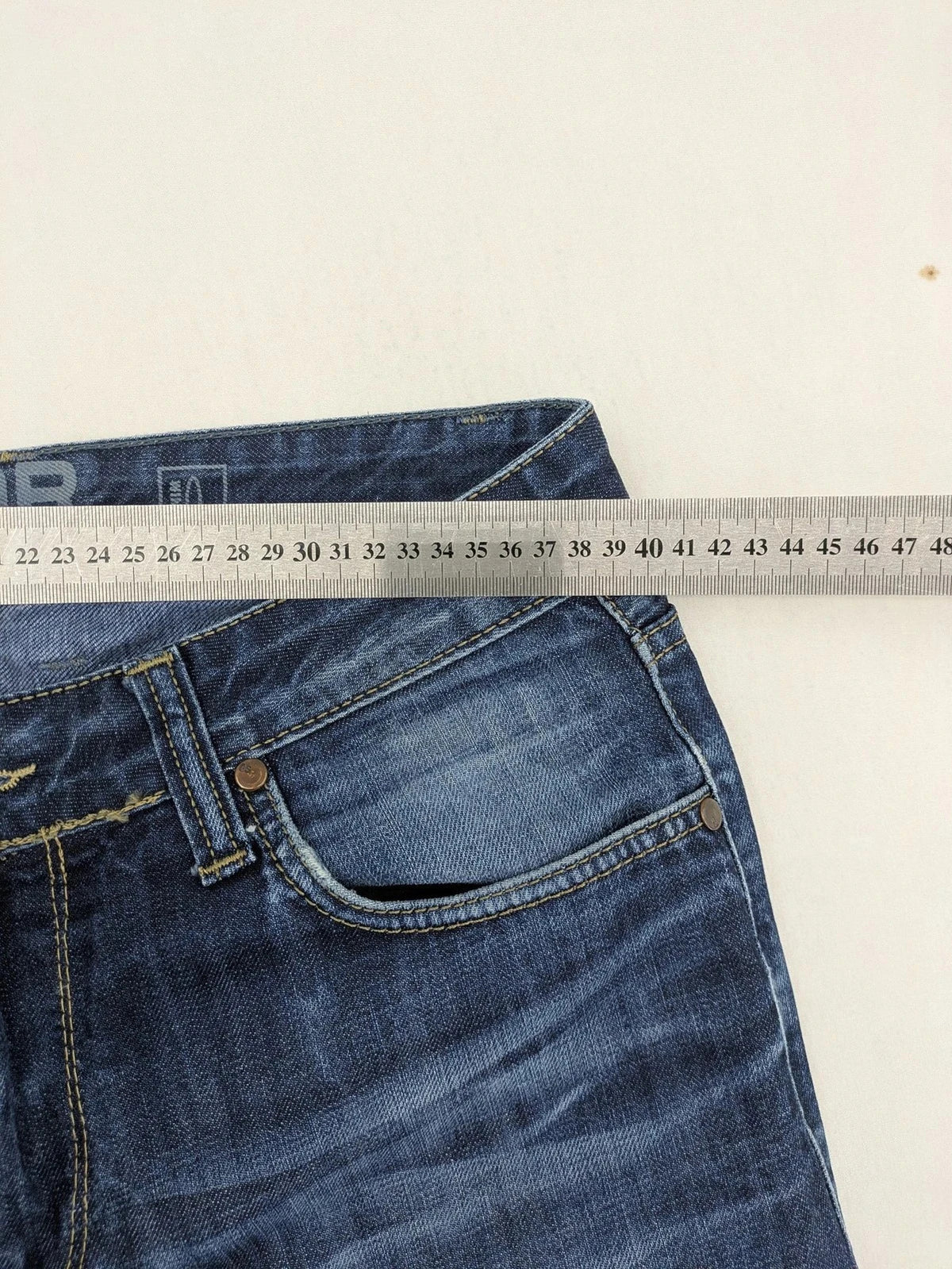 G-Star blue straight jeans with faded wash and whiskering effects, durable denim material.