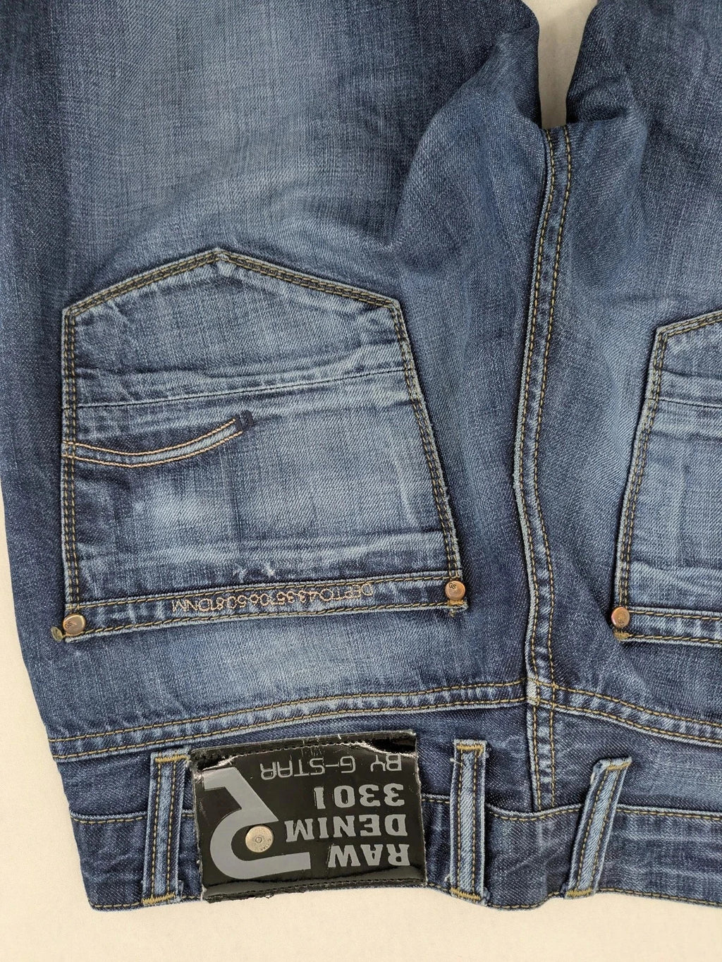 G-Star blue straight jeans with faded wash and whiskering effects, durable denim material.