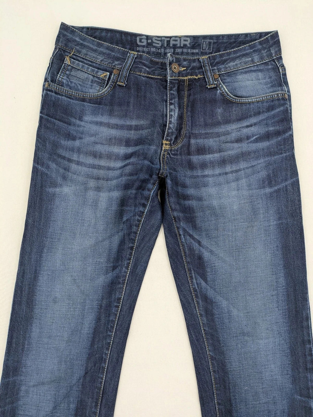 G-Star blue straight jeans with faded wash and whiskering effects, durable denim material.