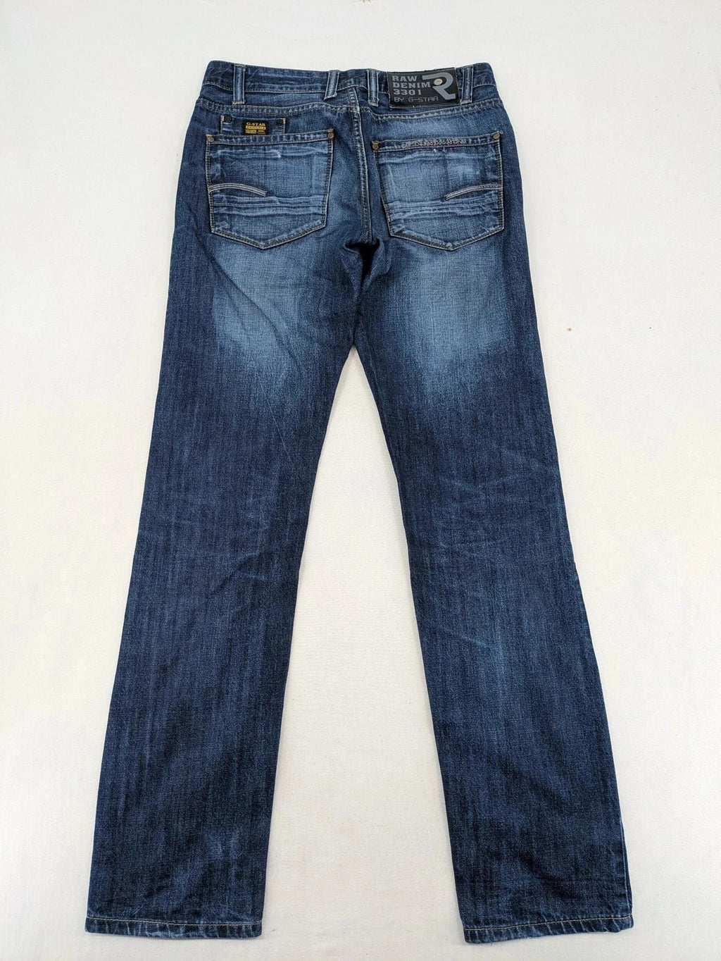 G-Star blue straight jeans with faded wash and whiskering effects, durable denim material.