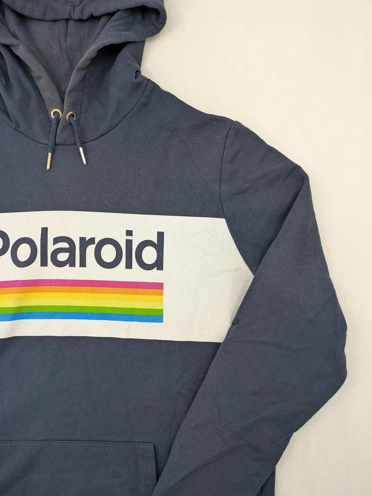 Polaroid blue graphic hoodie featuring iconic logo print with rainbow stripes and kangaroo pocket.
