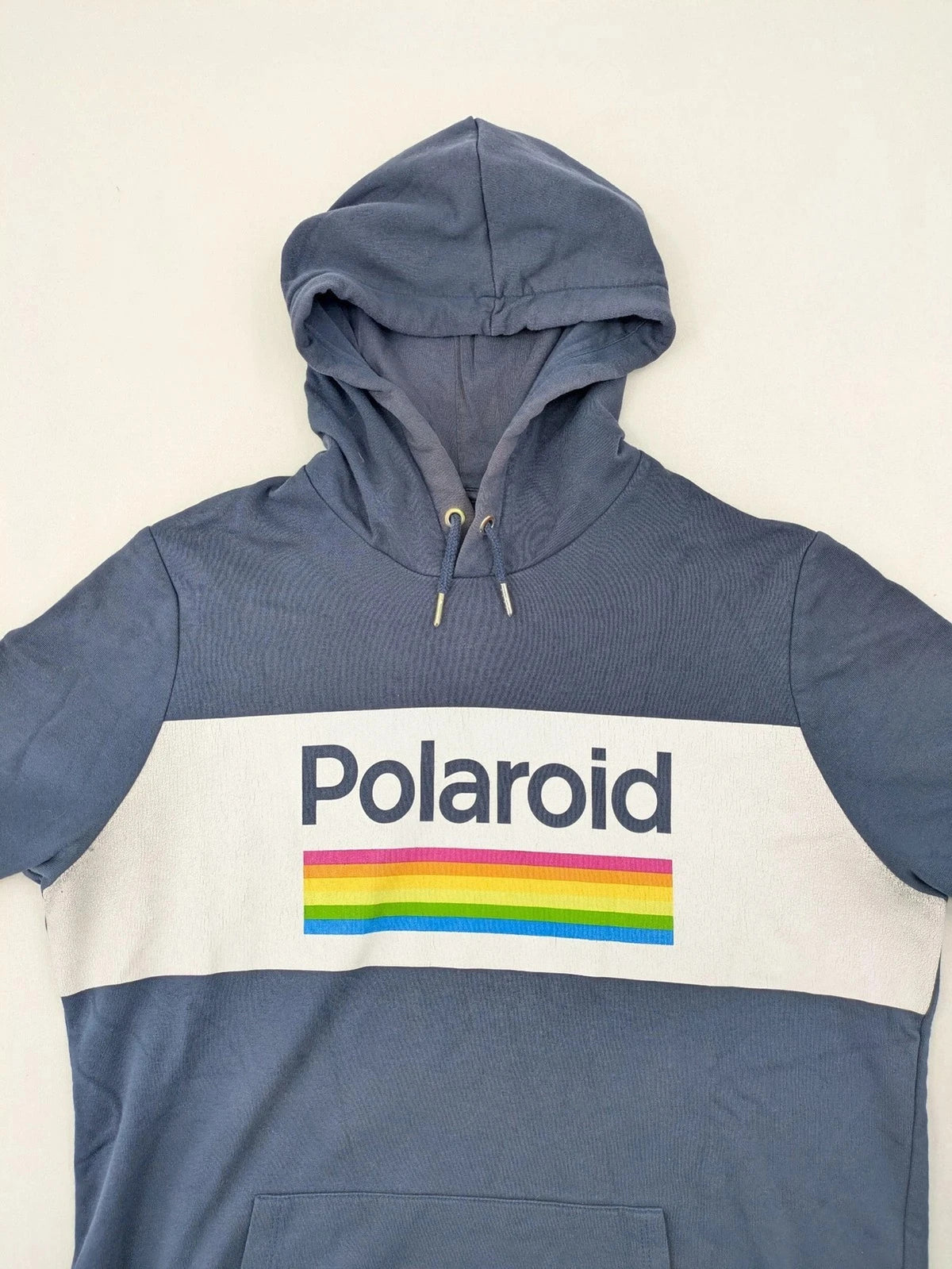 Polaroid blue graphic hoodie featuring iconic logo print with rainbow stripes and kangaroo pocket.