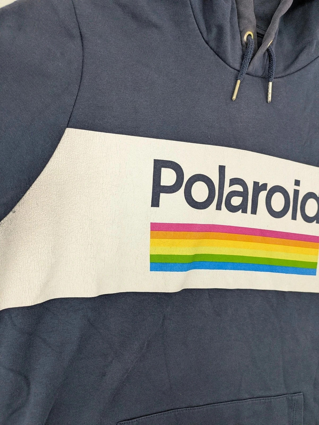 Polaroid blue graphic hoodie featuring iconic logo print with rainbow stripes and kangaroo pocket.