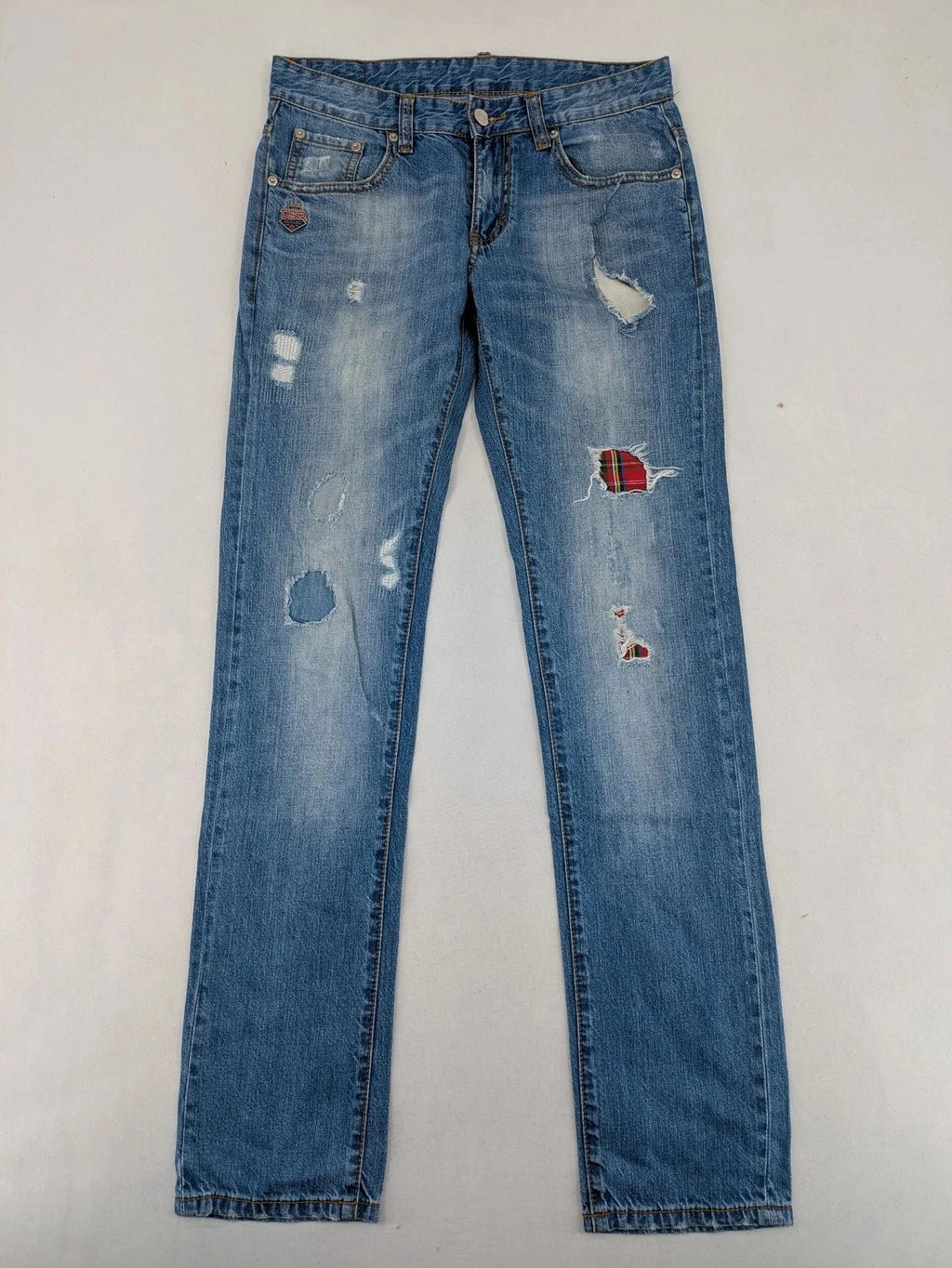 Andrew & Angel blue straight jeans distressed with red tartan patches and worn details.