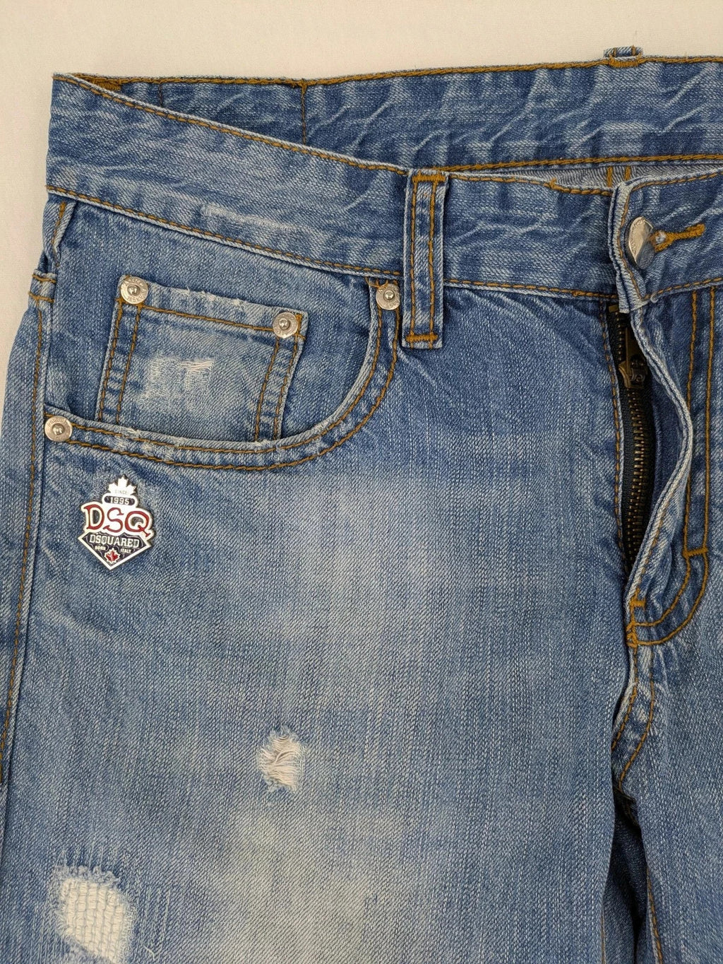 Andrew & Angel blue straight jeans distressed with red tartan patches and worn details.