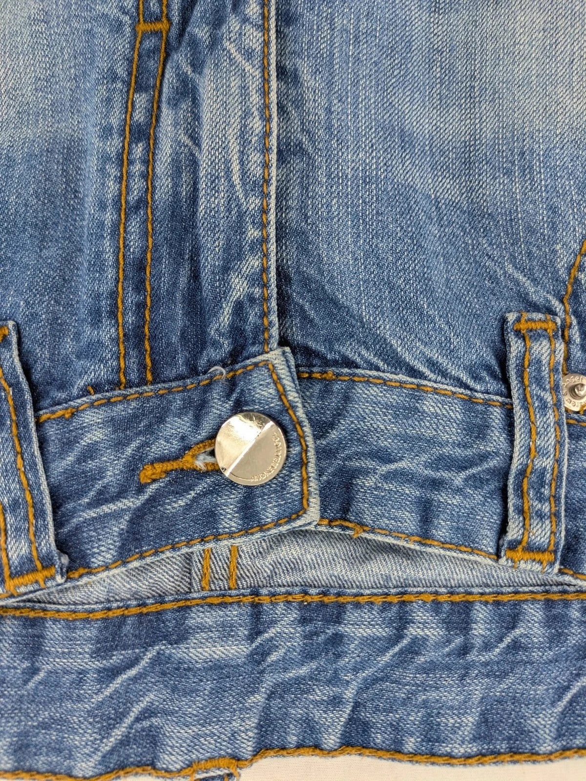 Andrew & Angel blue straight jeans distressed with red tartan patches and worn details.