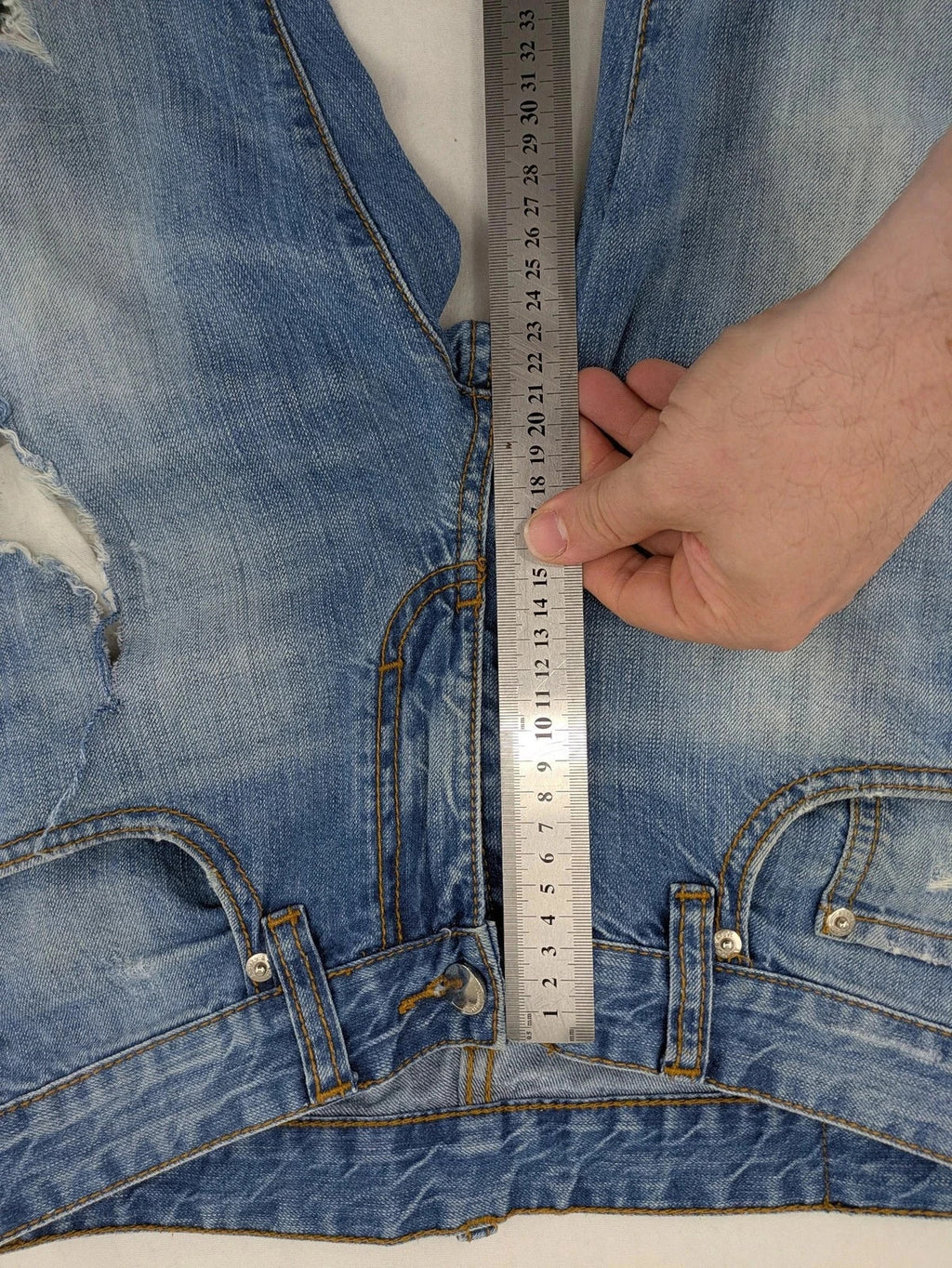 Andrew & Angel blue straight jeans distressed with red tartan patches and worn details.