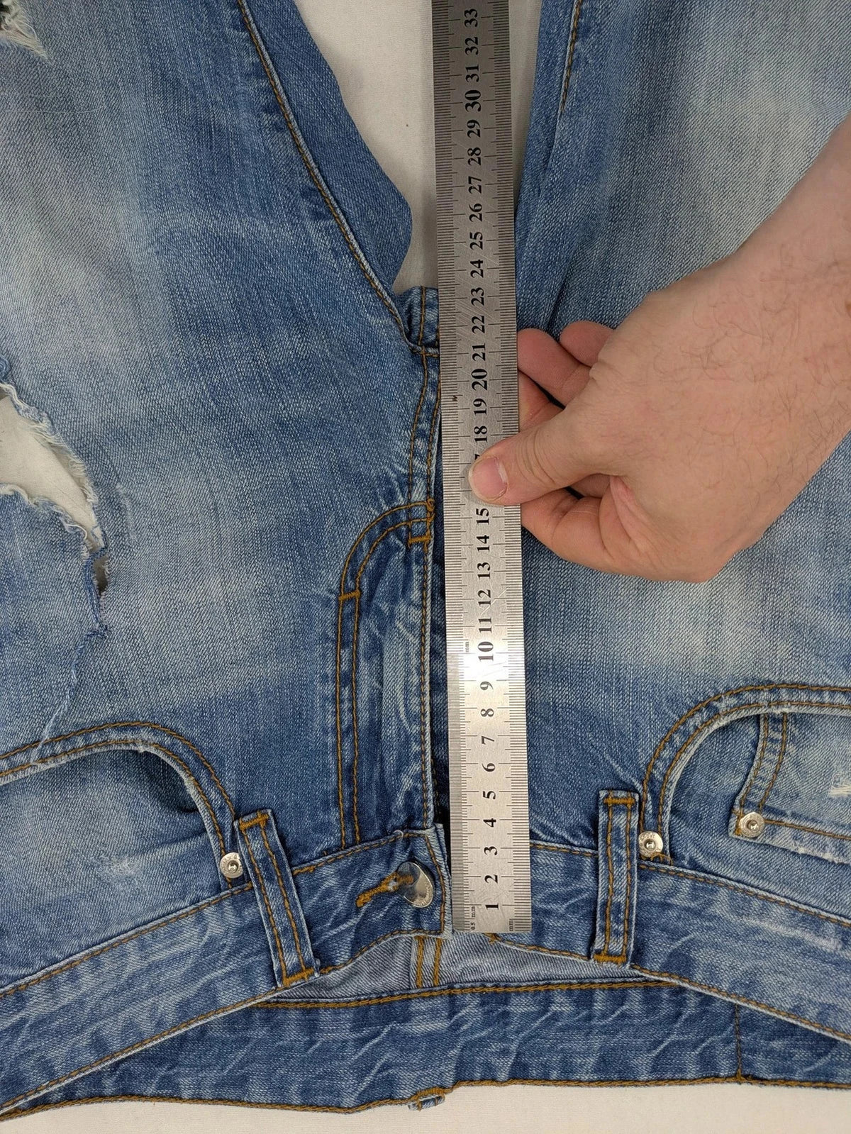 Andrew & Angel blue straight jeans distressed with red tartan patches and worn details.