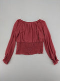 Melitea pink crop top with smocked waist and voluminous balloon sleeves.