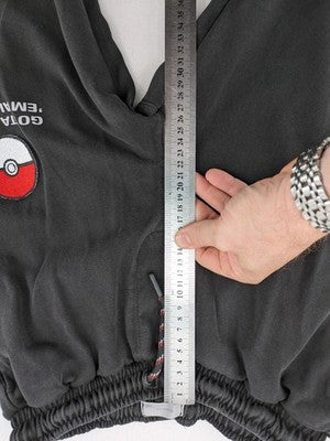 Herren grey jogging pants large Pokémon graphic print and embroidered Pokéball patch.