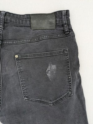 H&M black distressed skinny jeans shorts with frayed hem and button fly detail.