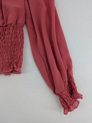 Melitea pink crop top with smocked waist and voluminous balloon sleeves.