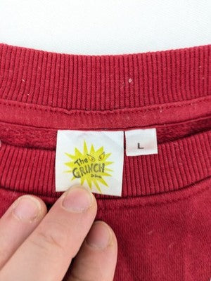 The Grinch red sweatshirt featuring large graphic of The Grinch in Santa suit