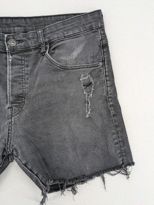 H&M black distressed skinny jeans shorts with frayed hem and button fly detail.