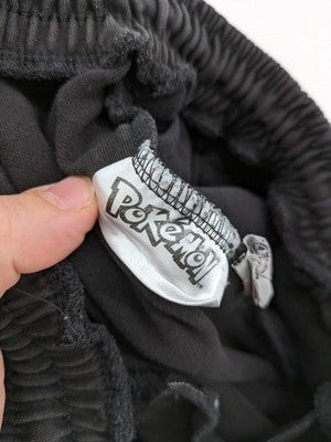 Herren grey jogging pants large Pokémon graphic print and embroidered Pokéball patch.