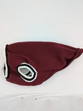 Burgundy dog sweater fleece lined with black and white striped trim, embroidered patch detail.