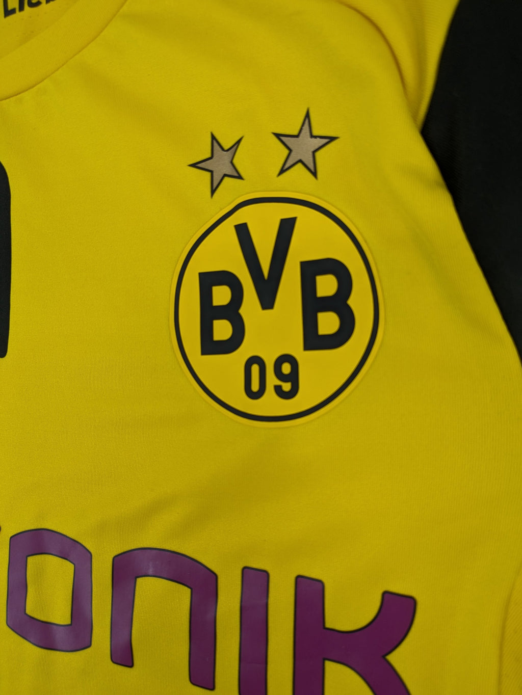 Puma black and yellow Borussia Dortmund soccer jersey with logo, stars, and sponsor print.