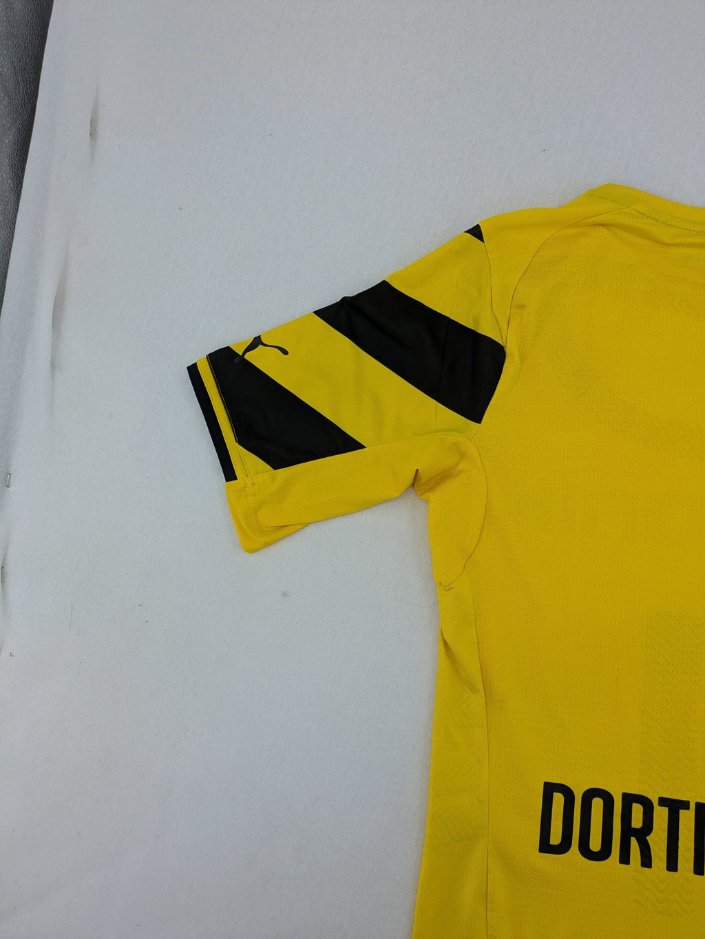 Puma black and yellow Borussia Dortmund soccer jersey with logo, stars, and sponsor print.