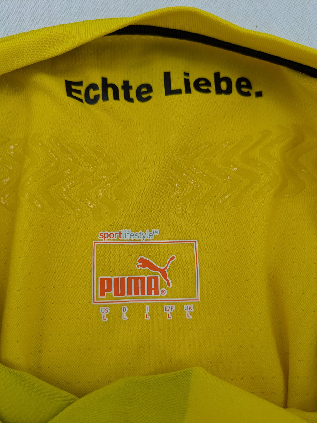 Puma black and yellow Borussia Dortmund soccer jersey with logo, stars, and sponsor print.
