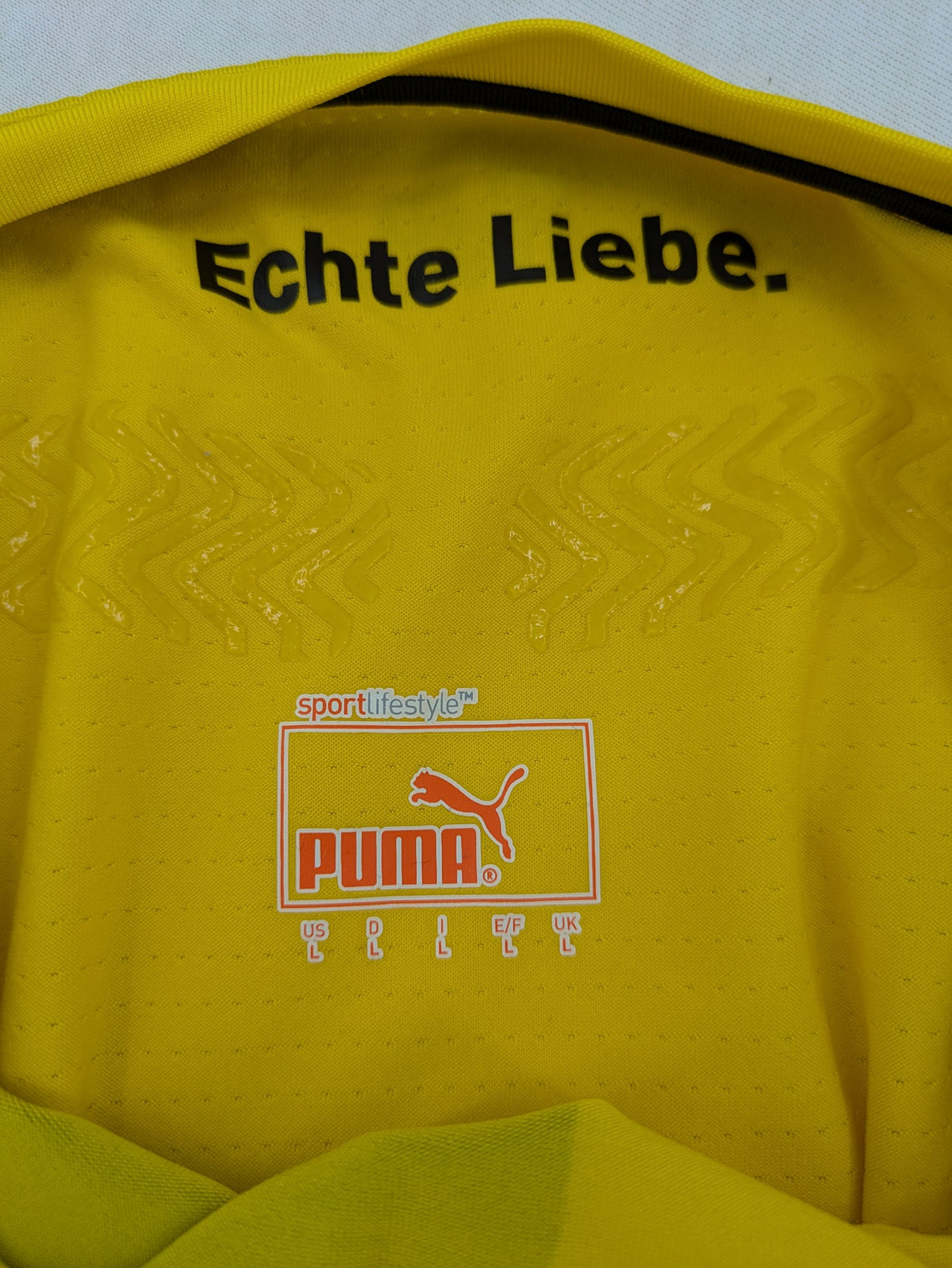Puma black and yellow Borussia Dortmund soccer jersey with logo, stars, and sponsor print.