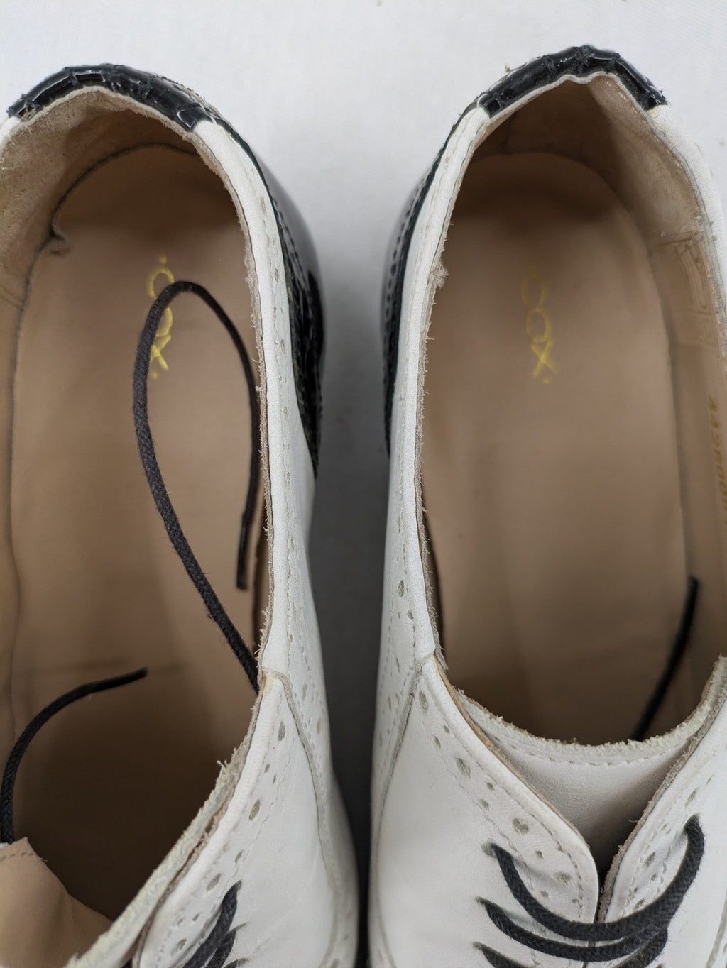 Kontrast black and white deck shoes, glossy patent leather with wingtip cap and brogue detailing.