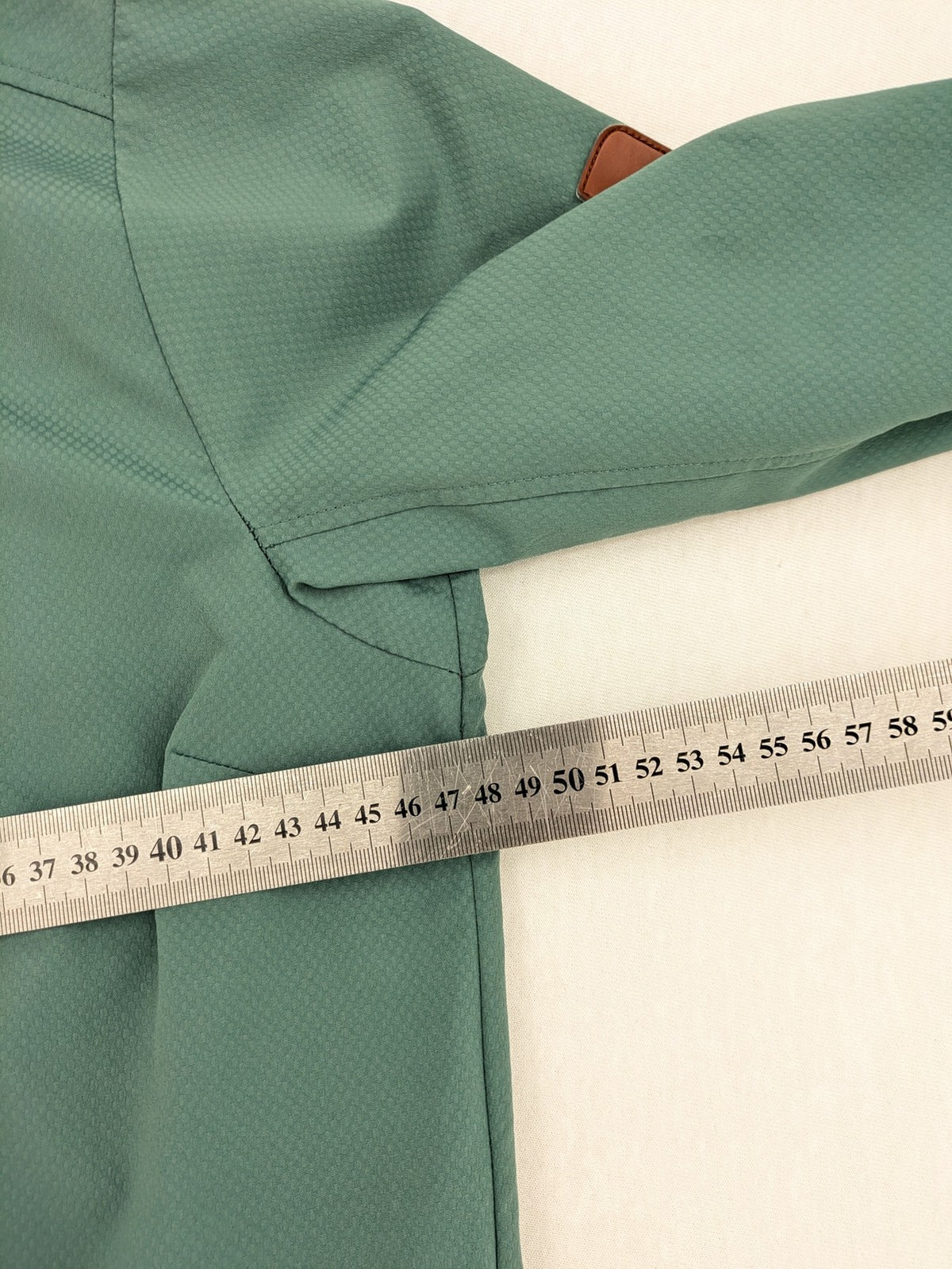 Frilufts green softshell jacket with hood, longline design, durable zipper, practical zip pockets.
