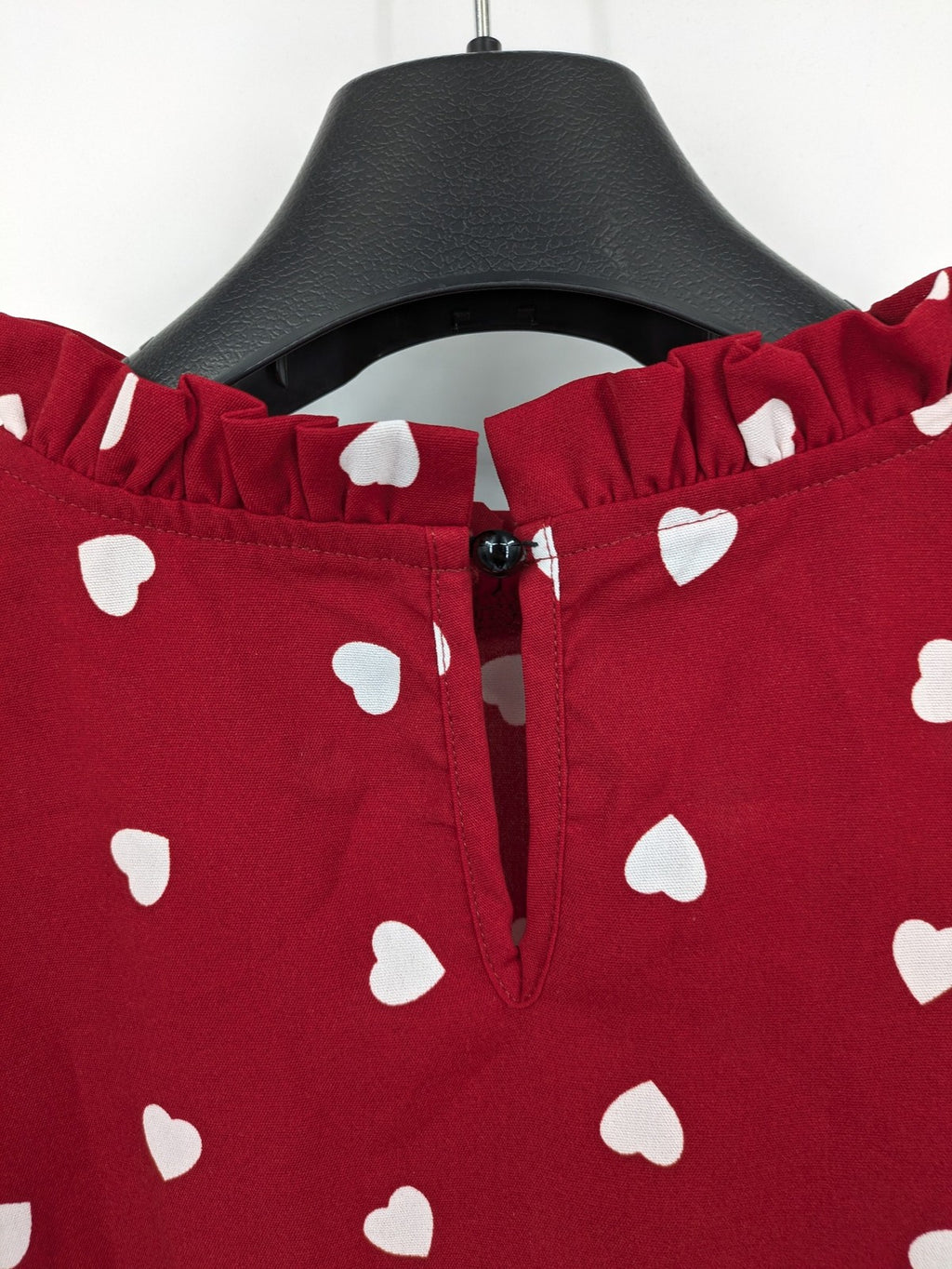 SHEIN burgundy top with white heart pattern and ruffled neckline detail.