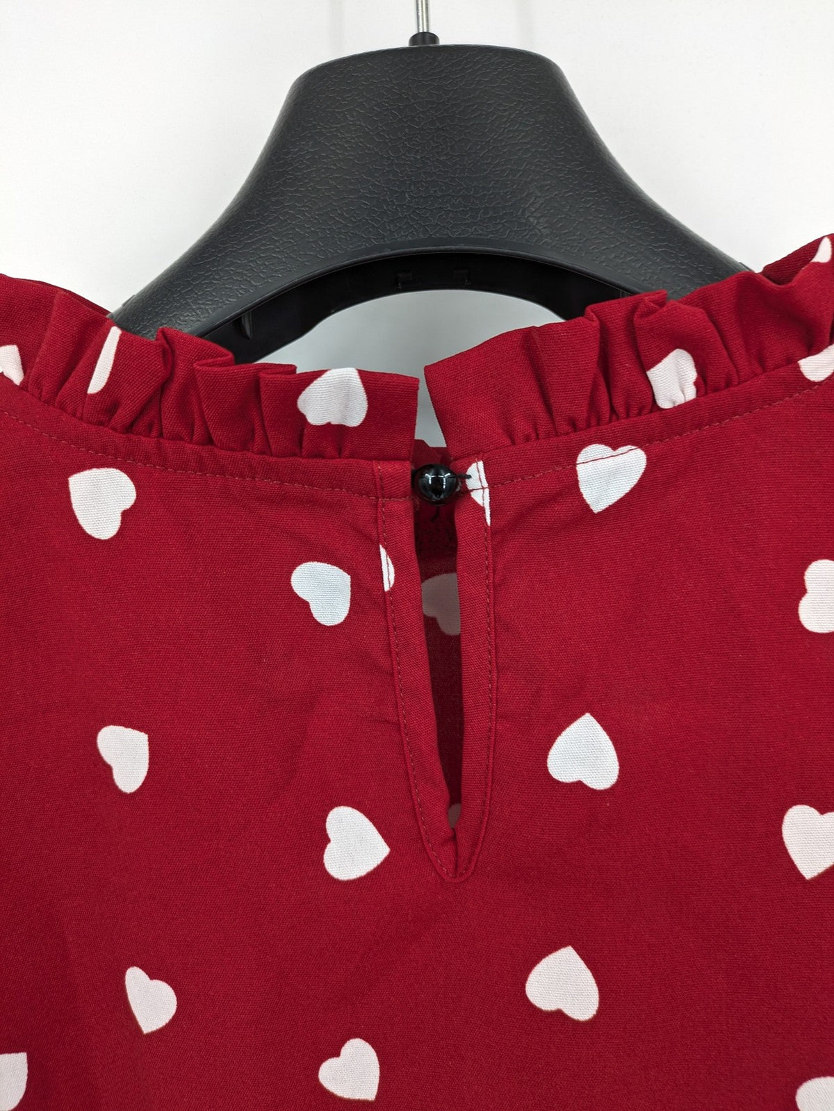 SHEIN burgundy top with white heart pattern and ruffled neckline detail.