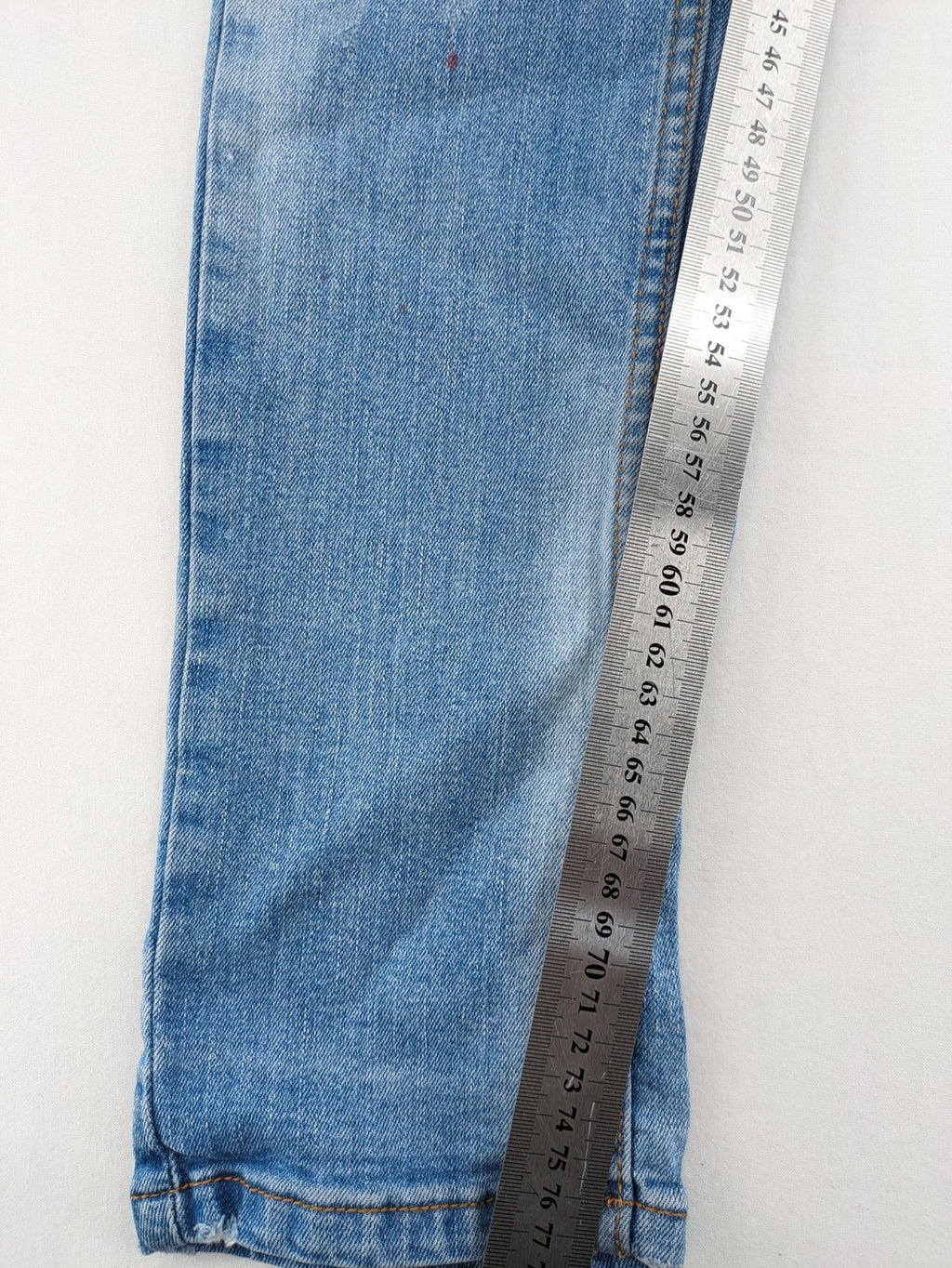 Milano straight jeans light blue distressed with red splatter and extra slim fit.