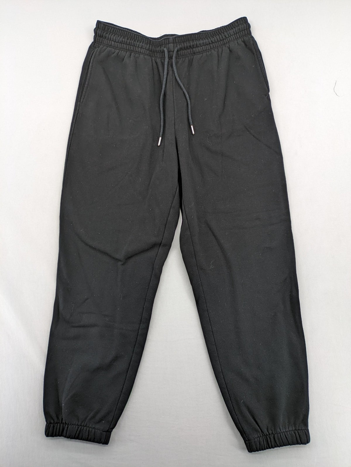 H&M black sweatpants with adjustable drawstring, elastic cuffs, and side pockets.