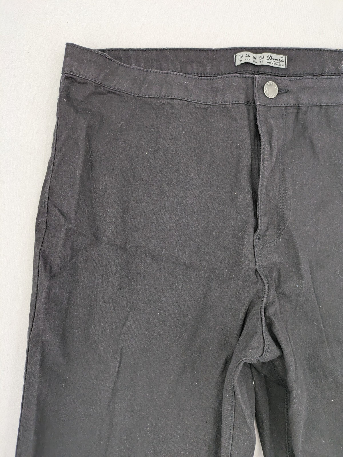 Denim & Co. black straight jeans with front button closure and back pockets.