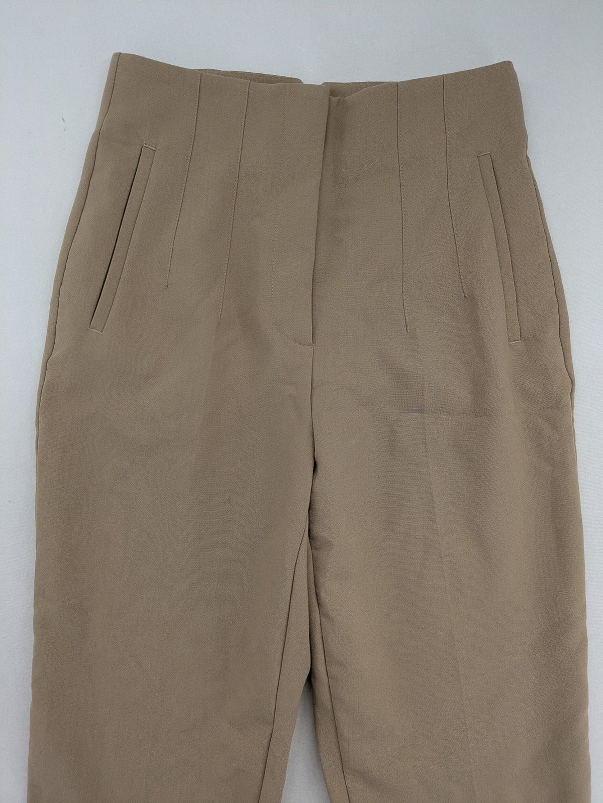 Tapered beige pants high-waist tapered fit with classic front creases and side pockets.