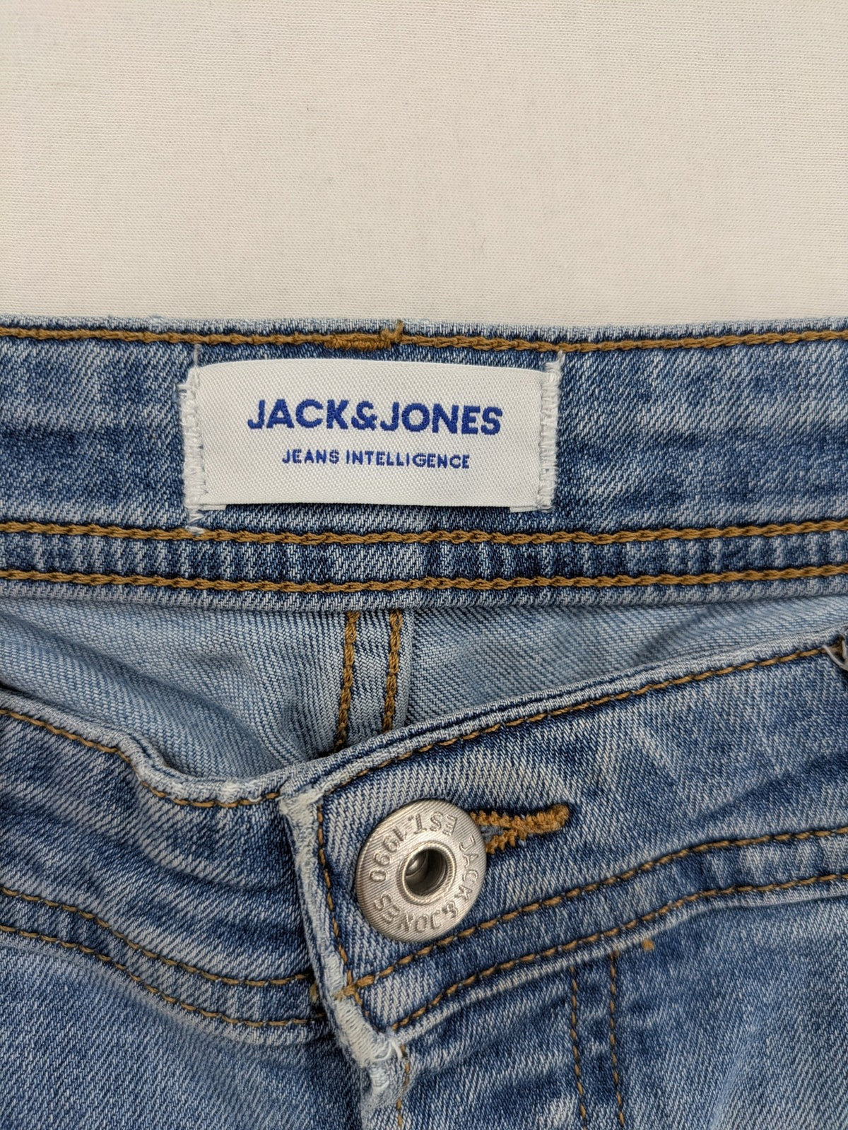 Jack & Jones blue slim jeans with button fly and subtle used look.