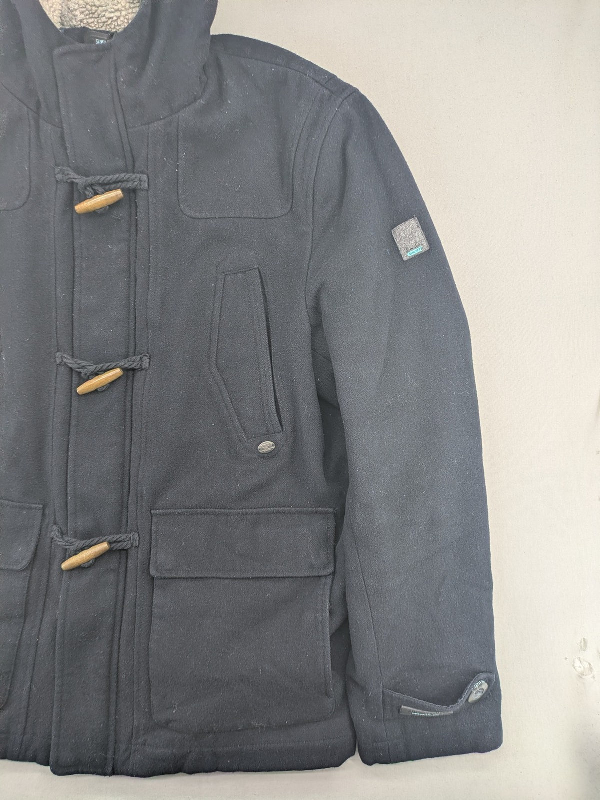 Angelo Litrico black duffle coat with toggle closure and cream Sherpa-lined hood.