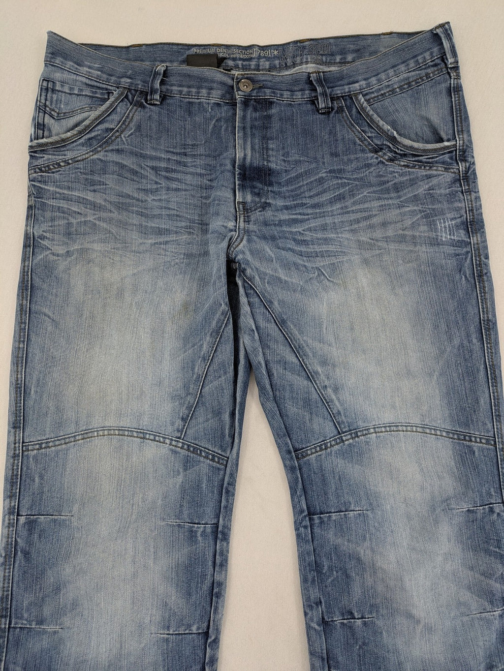 Premium Denim blue straight leg jeans with biker knee inserts and five-pocket design.