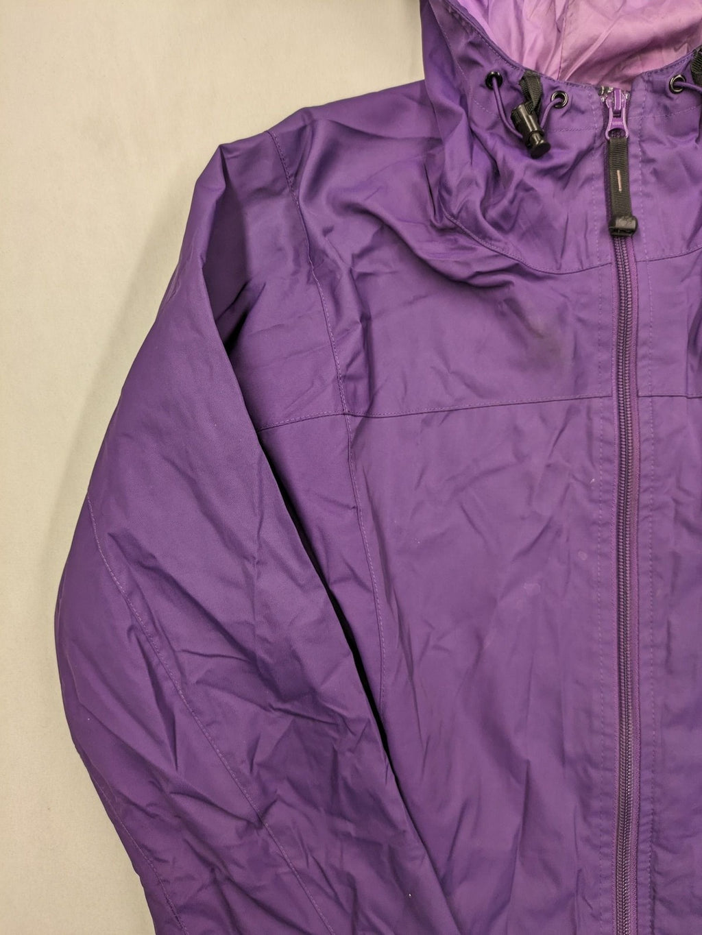 Jack Wolfskin purple outdoor jacket with adjustable hood and full zip, lightweight Stormlock material.