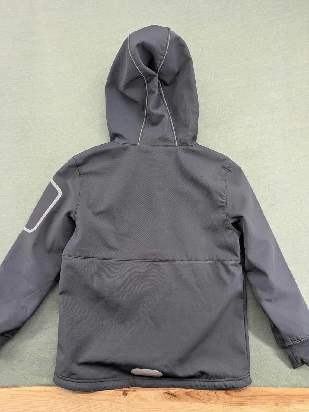 Yigga grey softshell coat with fleece lining, hood, and reflective details.