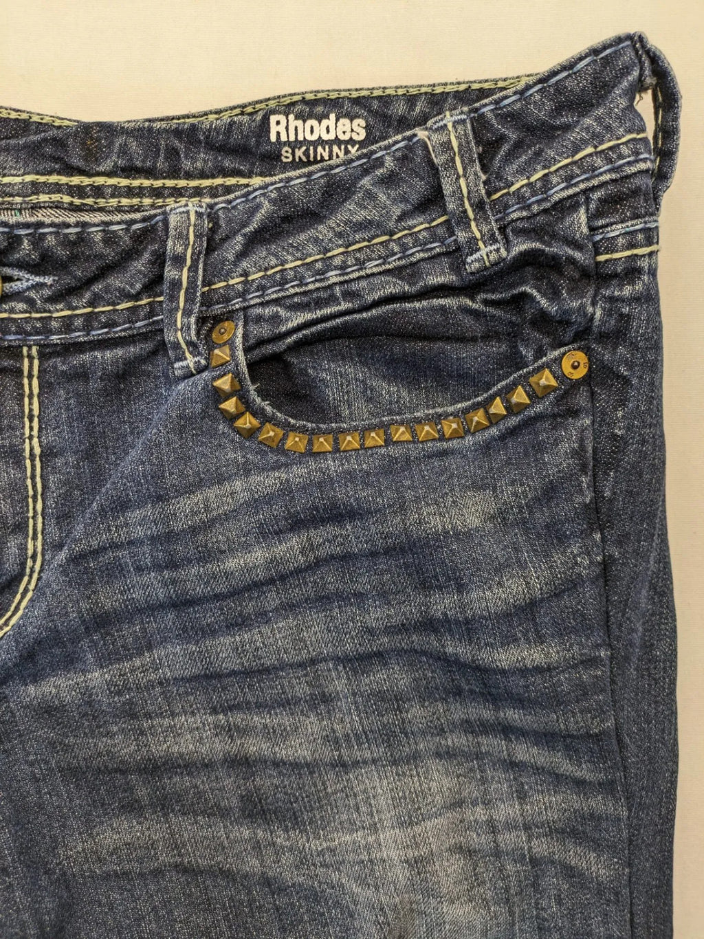 Rhodes blue skinny jeans with decorative studs and intricate embroidery on back pockets.