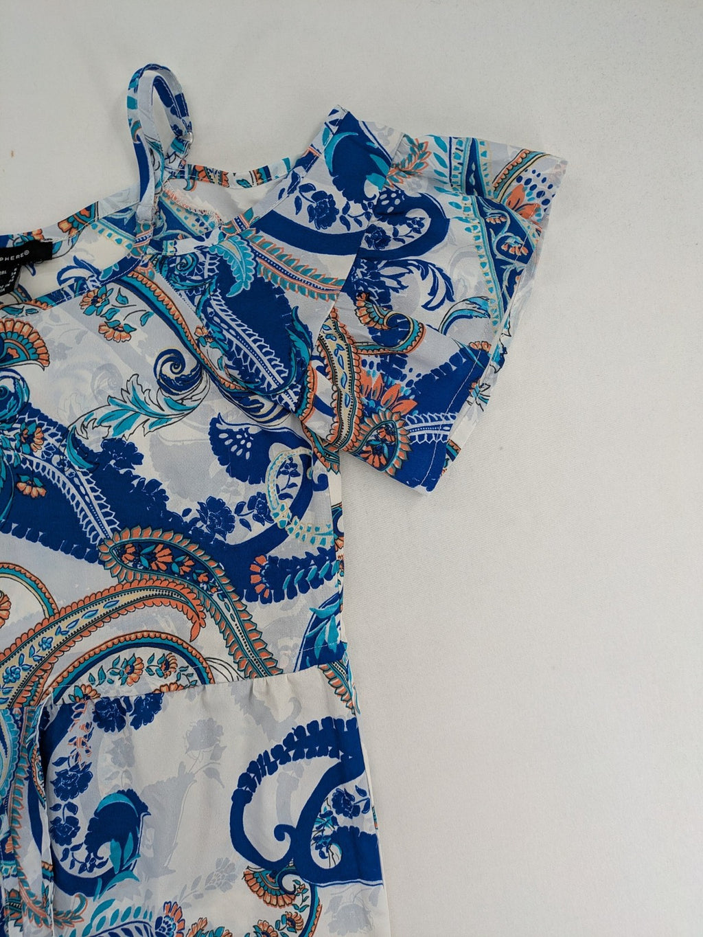 Atmosphere orange summer dress with colorful paisley pattern and cold shoulder design.