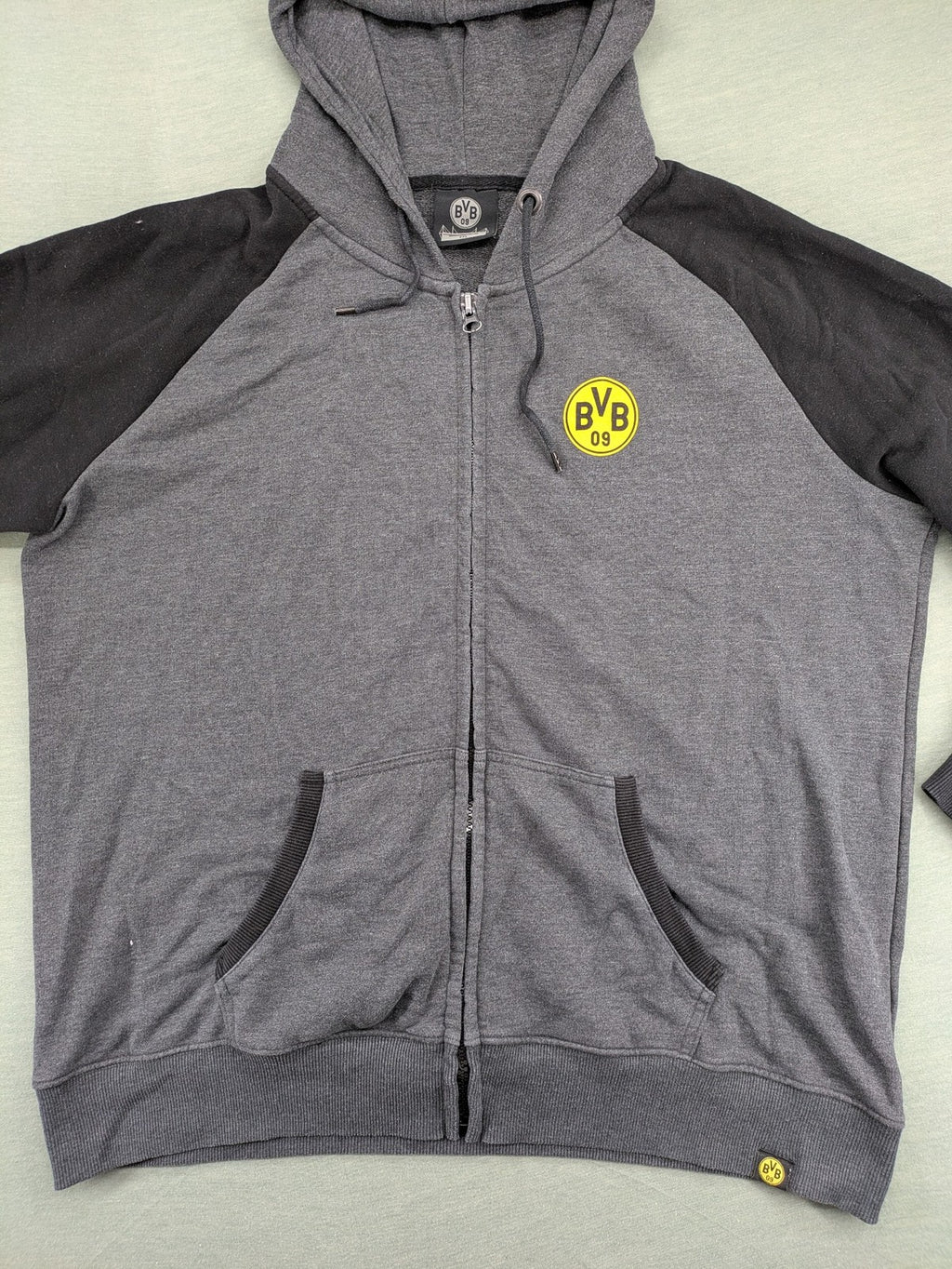 Borussia Dortmund grey and black hoodie with BVB 09 logo and full zip design.