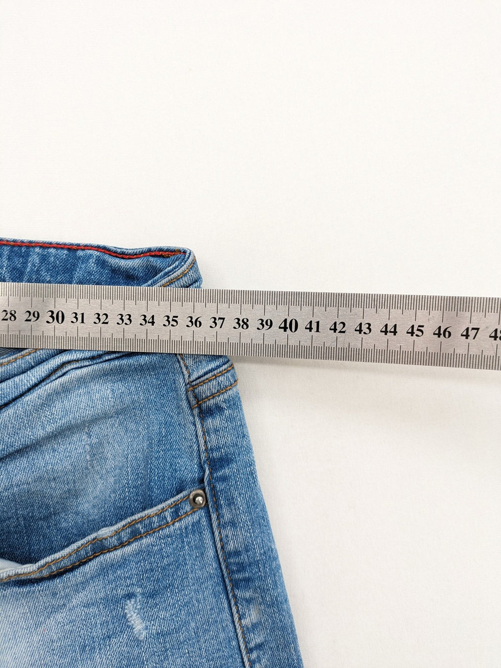 Milano straight jeans light blue distressed with red splatter and extra slim fit.