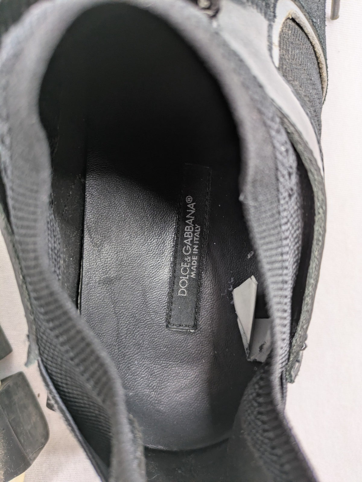 Dolce & Gabbana black sneakers with logo laces and segmented sole design.