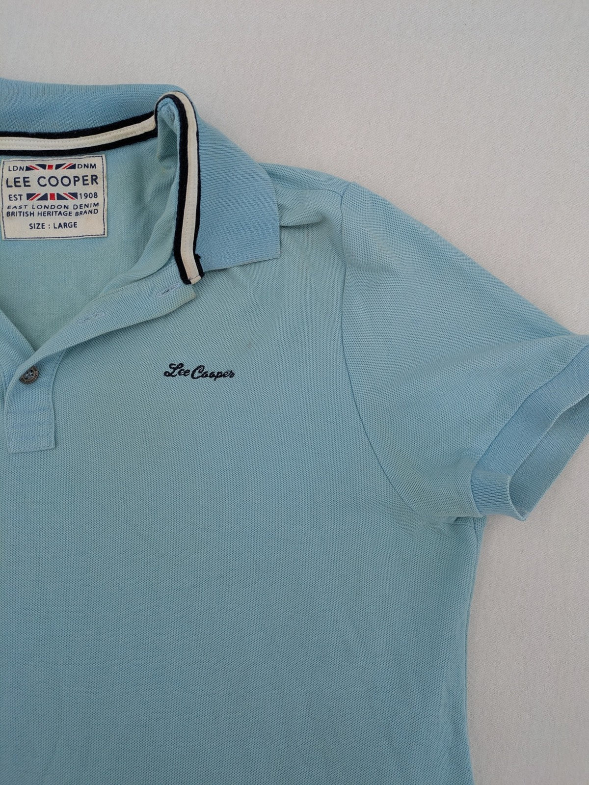Lee Cooper blue polo shirt with embroidered logo and Union Jack patch on sleeve.