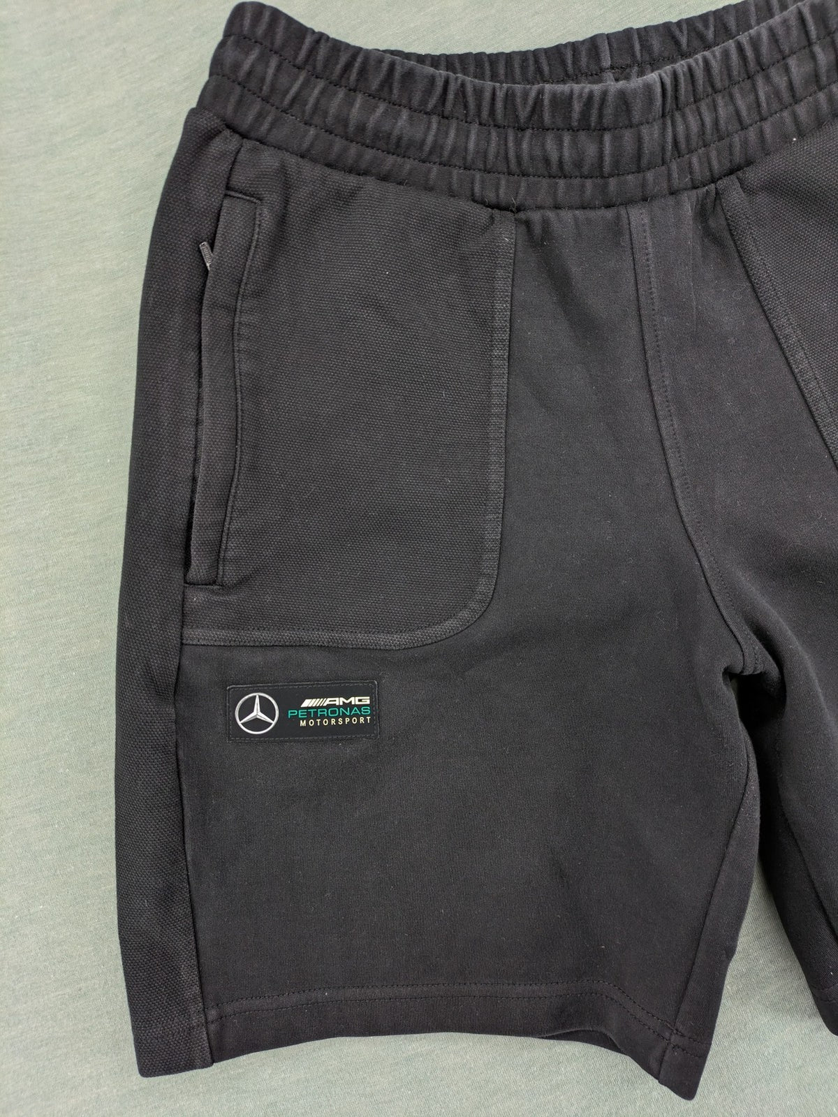 Puma grey sweatshorts featuring Mercedes AMG Petronas logo and elastic waistband.
