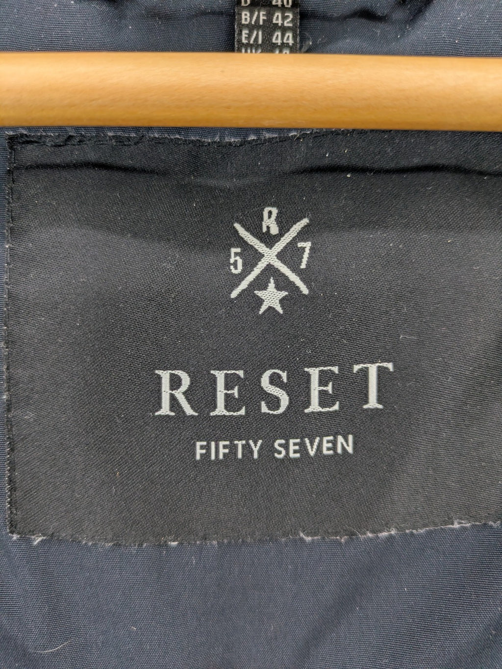 Reset Fifty Seven cream puffer coat with faux fur hood and down insulation.
