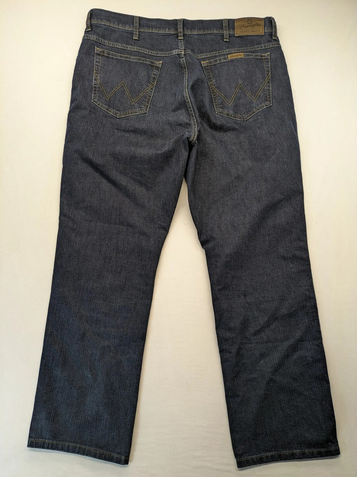 Wrangler straight jeans dark blue wash 5-pocket design with zipper, durable cotton blend.