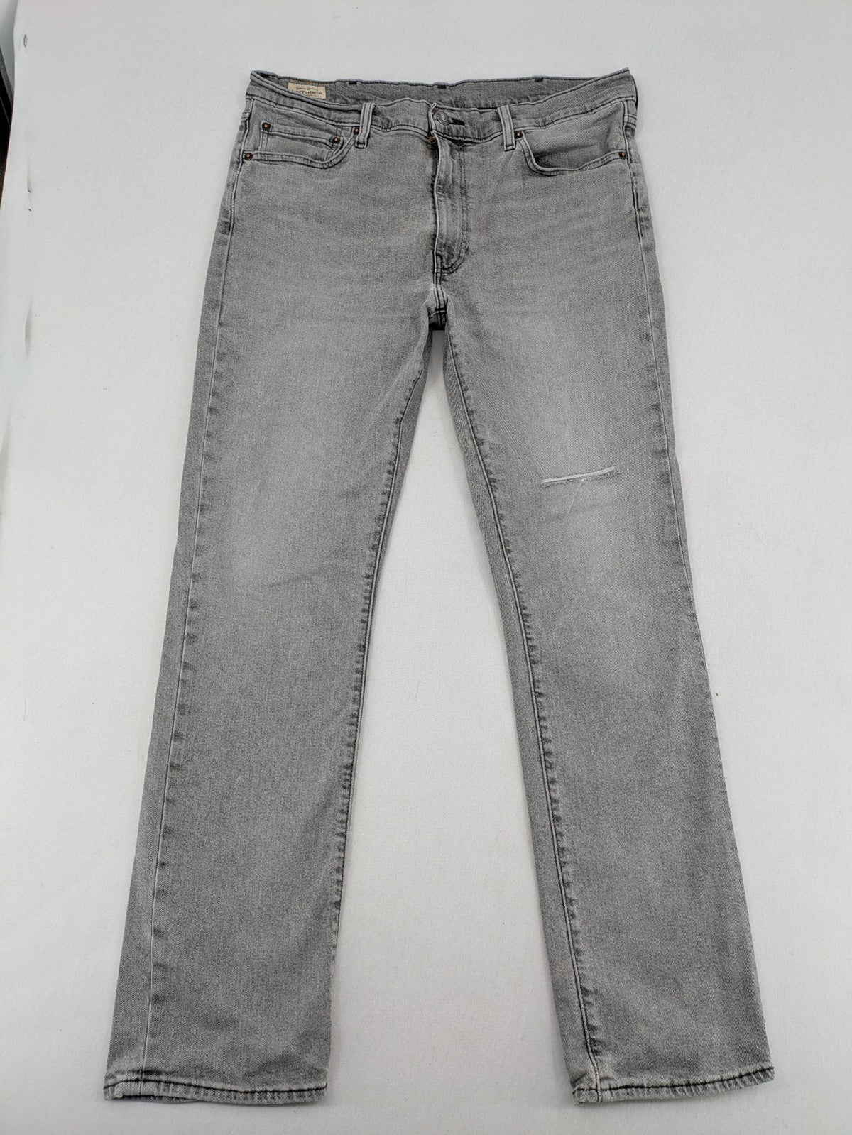 Levi's grey slim fit jeans with distressed knee details and classic logo patch.