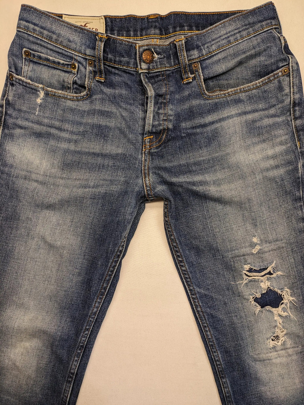 Hollister blue slim fit jeans with distressed detailing and classic button fly.