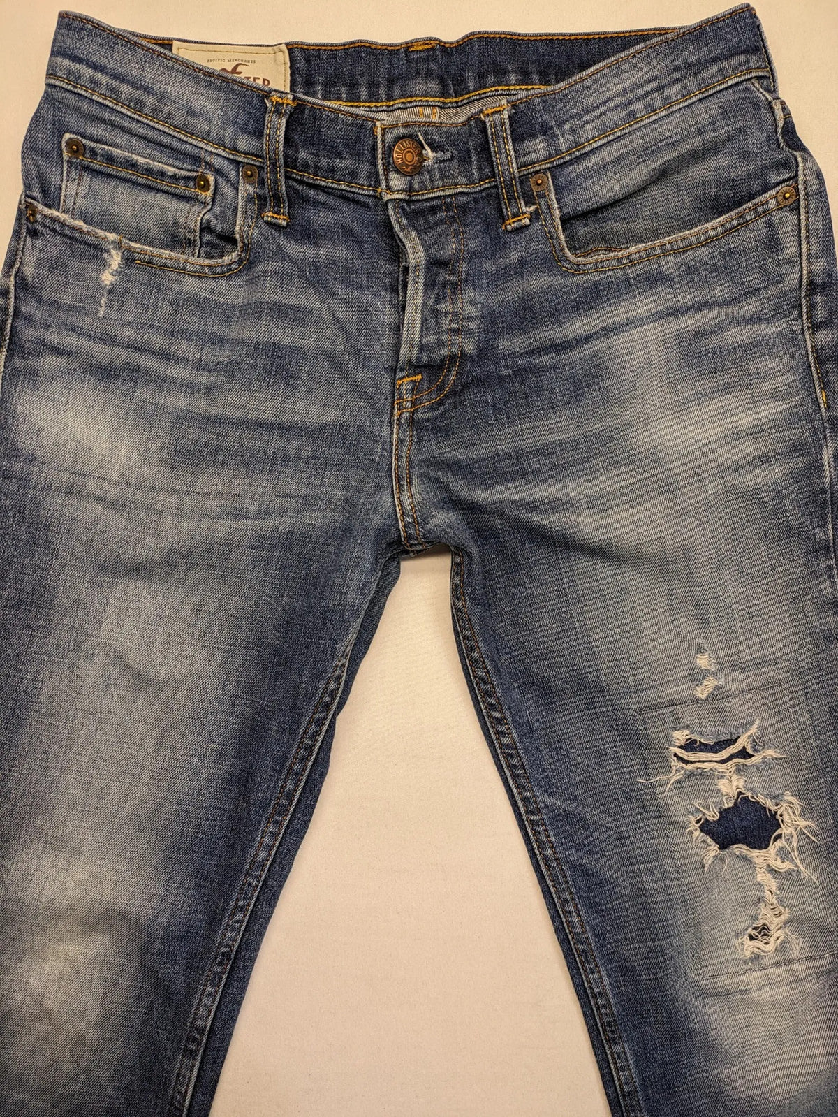 Hollister blue slim fit jeans with distressed detailing and classic button fly.