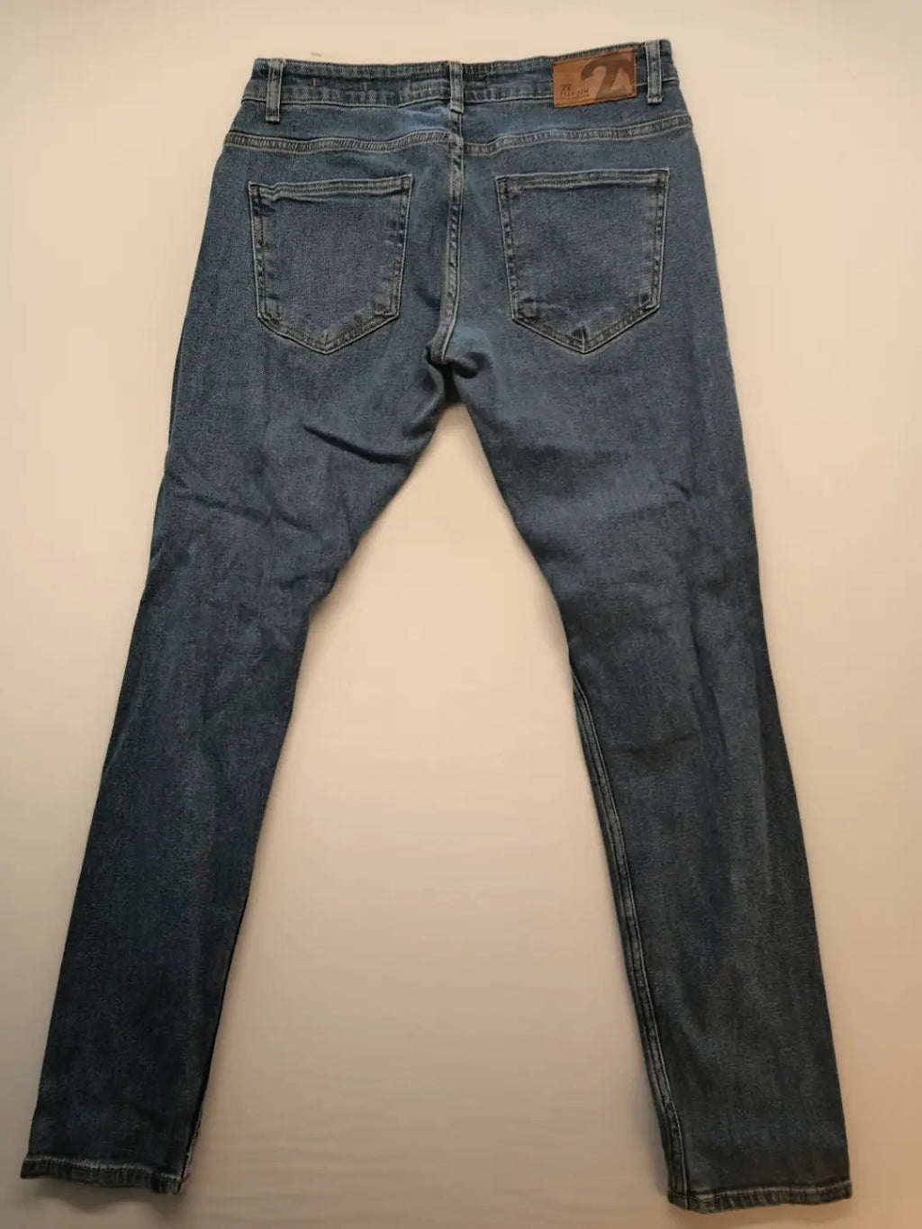 Damen blue skinny jeans with ripped details, five-pocket style, and classic button closure.
